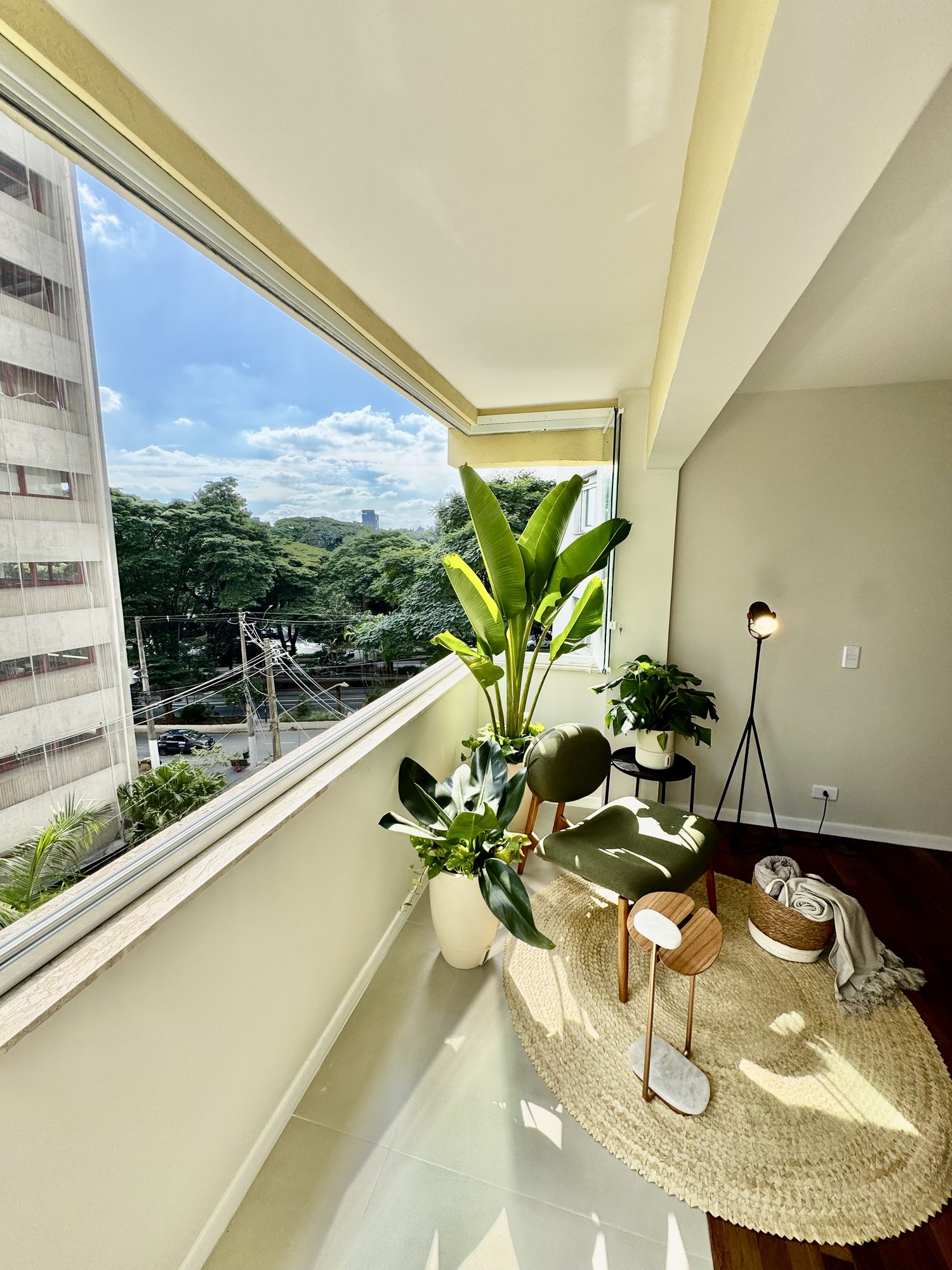 Varanda envidraçada com vista para as copas do Jardim América